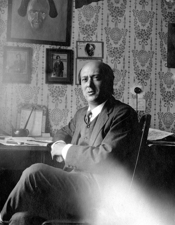 El compositor Arnold Schönberg en 1911, con un retrato de Gustav Mahler a sus espaldas.